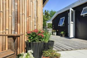 a wooden deck with flowers on a house at Holiday Home With A Direct Path To The Sea in Korsør