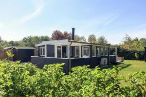 a black tiny house sitting in a yard at Holiday Home With A Direct Path To The Sea in Korsør