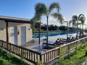 a wooden deck with lounge chairs and a swimming pool at Apto 2Q com Area de Lazer e Piscina in São Gonçalo do Amarante