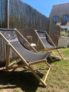 two deck chairs sitting in a yard next to a fence at The Cotton Suites B&B in Deerlijk +90 photos