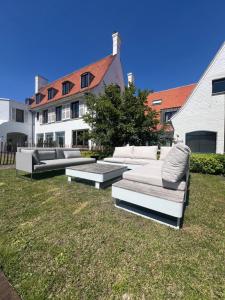 a group of couches sitting on the grass in a yard at The Cotton Suites B&B in Deerlijk