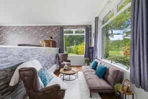 a living room with two chairs and a couch at Five Marches - Poolside Stays with Stunning Views in Angus