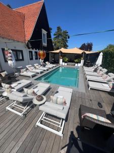 a group of lounge chairs and a swimming pool at The Cotton Suites B&B in Deerlijk