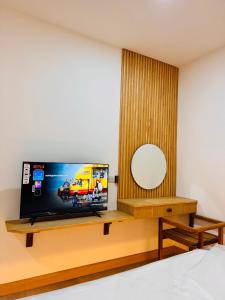 a bedroom with a flat screen tv on a wooden table at Meena boutique in Ban Nai Wat