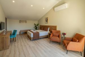 a hotel room with a bed and two chairs at No 14 HOTEL GÖCEK in Göcek