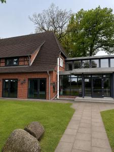 a red brick building with windows and a lawn at ELO STAY Nordheide 24h Check-in, Free Parking and WiFi in Buchholz in der Nordheide