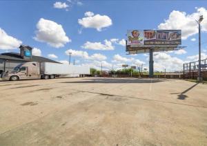 a semi truck parked in a parking lot with a billboard at Hotel Blue Baytown, Texas in Baytown