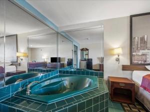 a bathroom with a tub in a hotel room at Hotel Blue Baytown, Texas in Baytown