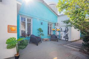 a blue house with two chairs and a bike at PASTORA Suites & Hostel - Punta del este in Punta del Este