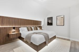 a bedroom with a large bed with a wooden headboard at Widmr Residences in Toronto