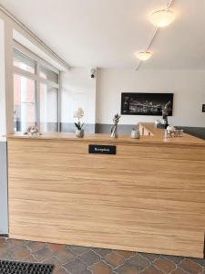 a large wooden counter in a room with a tv at ELO STAY Nordheide 24h Check-in, Free Parking and WiFi in Buchholz in der Nordheide