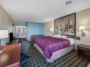 a hotel room with a large bed and a desk at Hotel Blue Baytown, Texas in Baytown