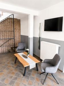 a living room with two chairs and a table and a tv at ELO STAY Nordheide 24h Check-in, Free Parking and WiFi in Buchholz in der Nordheide