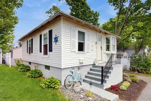 a white house with a bike parked outside of it at Salt & Petal in Old Orchard Beach