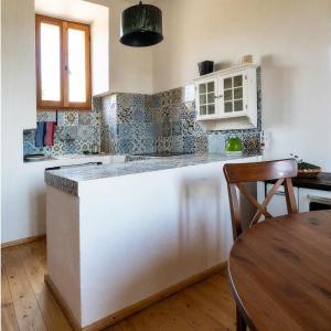 a kitchen with a white counter and a wooden table at La Salvia in Scansano