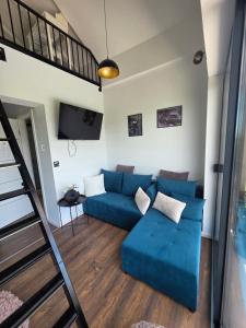 a living room with a blue couch and a loft at The Dream house in Tomaš