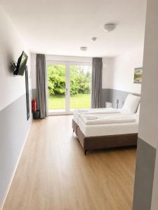 a bedroom with a bed and a large window at ELO STAY Nordheide 24h Check-in, Free Parking and WiFi in Buchholz in der Nordheide +18 photos