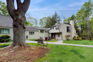 a bench sitting next to a tree in front of a house at Quechee's Cloud 9 in Hartford