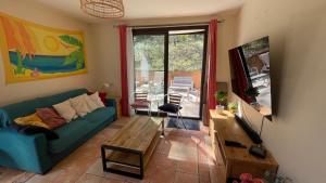 a living room with a couch and a table at Villa Salagou - Vue sur le lac - Liausson 34800 - 6-8 pers - 100m2 in Liausson