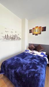 a bedroom with a blue comforter on a bed at TORREMIA apartamentos de lujo in Cochabamba +81 photos