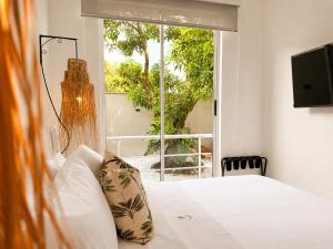 a bedroom with a bed and a large window at Palmará Hotel in Villeta