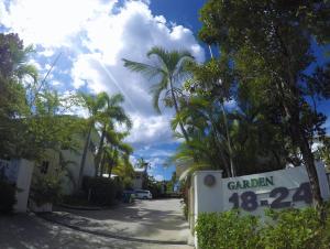 a street sign in front of a house with palm trees at Crystal Garden Resort & Restaurant in Cairns