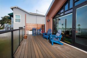 two blue chairs sitting on a wooden deck at Harbor View 101 in Morro Bay