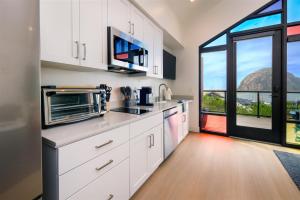 a kitchen with white cabinets and a large window at Harbor View 101 in Morro Bay