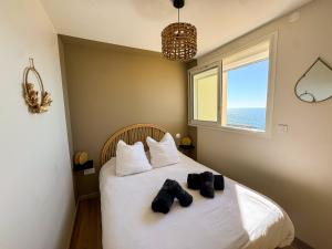 a bedroom with a bed with two pairs of shoes on it at La Tour Somma in Valras-Plage