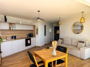 a living room with a table and a couch at La Tour Somma in Valras-Plage