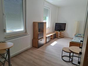 a living room with a tv and a table and chairs at NEU! Fewo Calbe an der Saale in Calbe