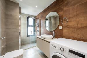 a bathroom with a washing machine and a mirror at Athenean Oasis in Ellinikon in Athens +241 photos