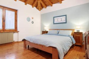 a bedroom with a bed and a wooden floor at Casa Pòlse in Baselga di Pinè