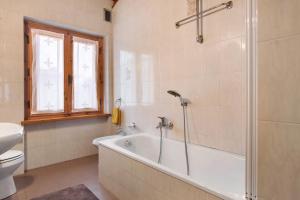 a bathroom with a tub and a toilet and a sink at Casa Pòlse in Baselga di Pinè +24 photos