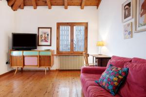 a living room with a couch and a flat screen tv at Casa Pòlse in Baselga di Pinè