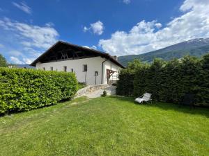 a white house with a bench in the grass at Ladurnhof in Silandro
