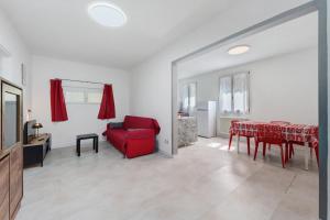 a living room with a red chair and a table at Casa Cortina in Domodossola