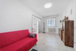 a living room with a red couch and a table at Casa Cortina in Domodossola