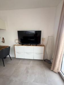 a flat screen tv sitting on top of a white cabinet at Casa Nova Apartment in Geislingen an der Steige +6 photos