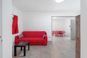 a living room with a red couch and a table at Casa Cortina in Domodossola