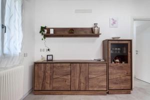a wooden cabinet in a room with a wall at Casa Cortina in Domodossola +17 photos