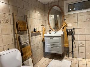 a bathroom with a sink and a mirror and a toilet at Cozy Garden Glamping in Svendborg