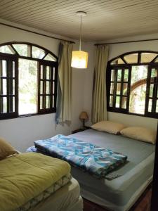 a bedroom with two beds and two windows at Chácara Luz do Vale in Votuverava +94 photos