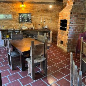 a kitchen with a wooden table and a brick wall at Chácara Luz do Vale in Votuverava