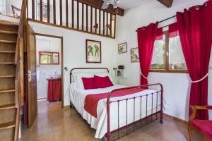 a bedroom with a bed and red curtains at Gite Insolite Mas Boutet in Argelès-sur-Mer