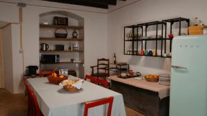 a kitchen with two tables and a refrigerator at Casa de São Roque in Avis