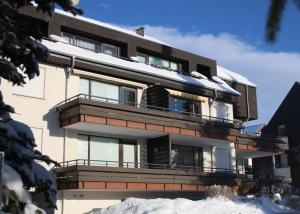 a building with balconies and snow on the ground at Welcome in - Studio 57-S mit Balkon, 200 m von der Skipiste entfernt in Winterberg