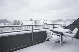 a balcony with a table and chairs and a view at Welcome in - Studio 57-S mit Balkon, 200 m von der Skipiste entfernt in Winterberg
