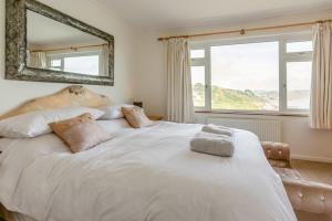a bedroom with a large white bed with a mirror at 2 Bed in Looe oc-l30026 in Looe