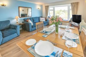 a living room with a table and a blue couch at 2 Bed in Looe oc-l30026 in Looe